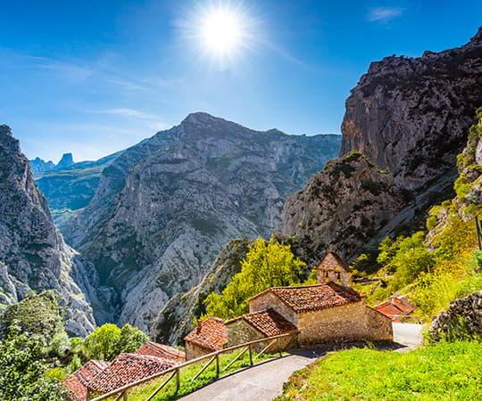Pueblo de Camarmeña con los Picos de Europa al fondo destacando el Picu Urriellu o Naranjo de Bulnes.