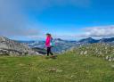 Senderista disfrutando de las vistas de las montañas asturianas bajo un cielo azul