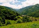 Valle asturiano con pueblos y vegetación abundante bajo un cielo nublado