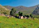 Cabaña rústica en un valle verde rodeado de montañas asturianas