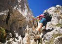 A hiker climbs a rock face