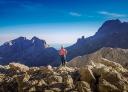 A hiker observes the spectacular mountain views along the route.