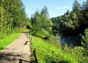 Rural footpath along the river with leafy trees on both banks