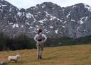 A hiker with his dog observes a mountainous landscape in Asturias.