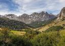 A cluster of peaks rises in the distance with a green valley below.