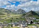 Mountain village with stone houses surrounded by green hills