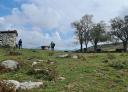 Two hikers admire the dolmen of Merillés while enjoying nature and the sun.