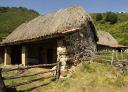 An old rural stone building with thatched roof, traditional architecture.