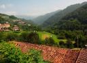 Panoramic view of an Asturian village in a green and mountainous valley.