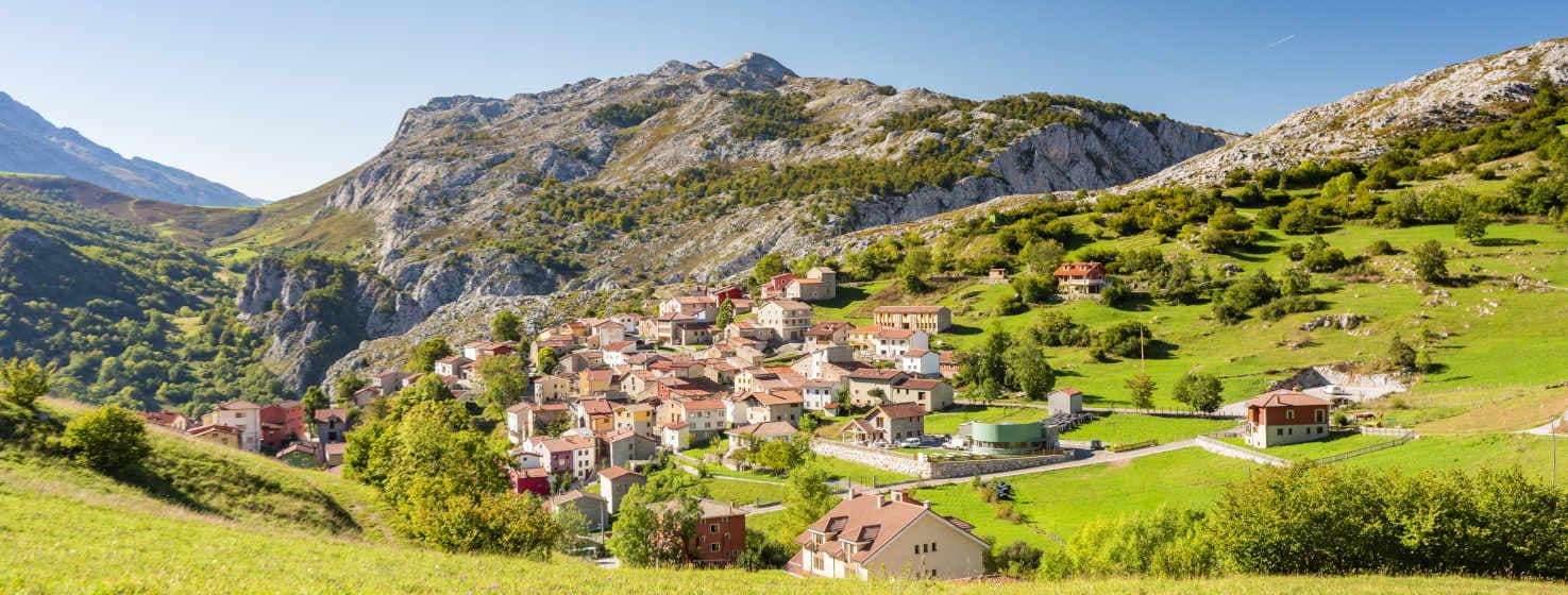 Vista geral de Sotres, a aldeia mais alta dos Picos da Europa, e Aldeia Exemplar de 2024 nos Prémios Princesa das Astúrias. Situada numa colina verdejante rodeada de montanhas, o maciço central do Parque Nacional.  Um punhado de casas brancas e de pedra com telhados vermelhos amontoam-se entre as suas ruas estreitas e íngremes.