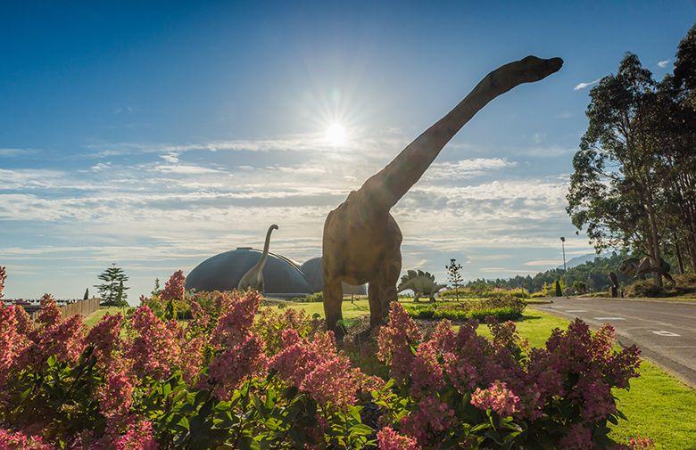 Foto dell'esterno del Museo Giurassico delle Asturie - MUJA di Colunga con la riproduzione di un brachiosauro in primo piano.