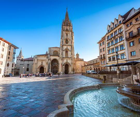 Photo of the façade of the Cathedral of El Salvador in Oviedo/Uviéu and its square with the fountain in the foreground