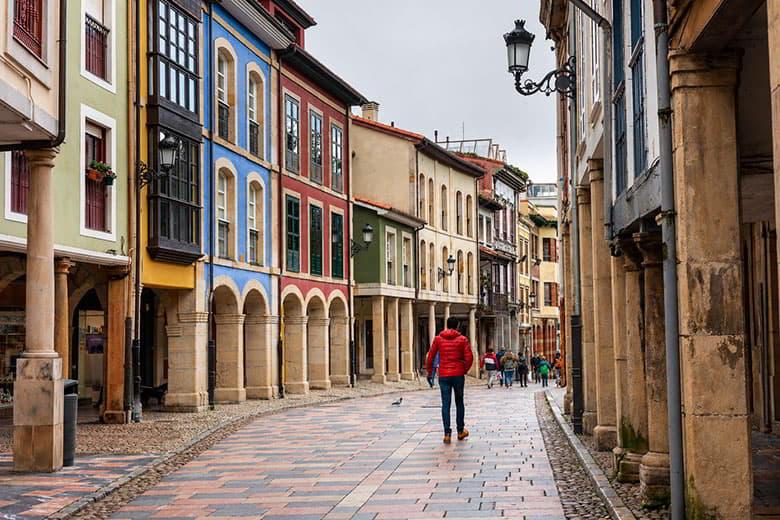 Calle Rivero en Avilés con soportales y fachadas de colores en día nublado