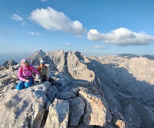 Fotografia de um casal de alpinistas no cimo de uma montanha