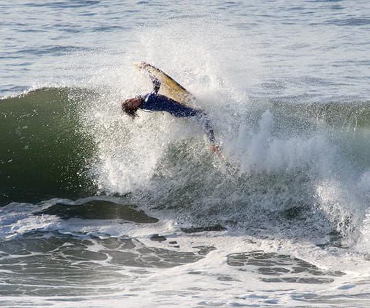 Surfista surfeando una ola en la playa de San Lorenzo en el concejo de Gijón.