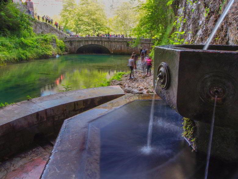 La Fuente de los Siete Caños in primo piano con il pozzo e le persone sullo sfondo.