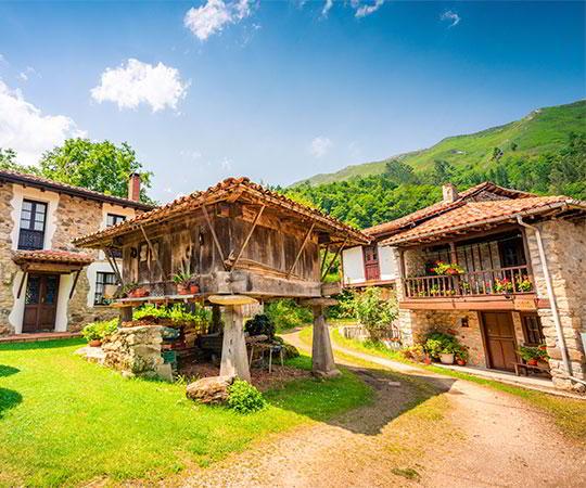 Photo d'un horreo en premier plan entouré de maisons dans le village d'Espinaréu. Commune de Piloña