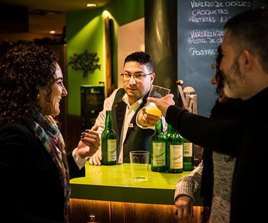 Fotografia de duas pessoas a comer numa casa de sidra