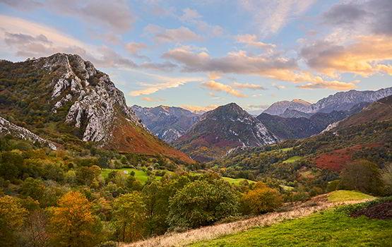 Imagem panorâmica da Collada de Moandi, no concelho de Ponga, com um caminho em primeiro plano entre montanhas.