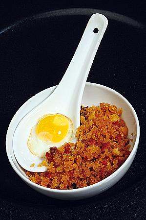 Cucharita de migas de boroña con picadillo de compango y yema de huevo