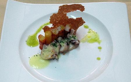 Octopus appetizer with olive and potato emulsion, accompanied by crispy octopus.